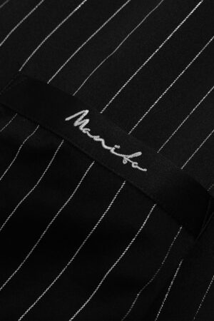 Embroidered MANITO logo detail on pocket of Galaxy pajama shirt.