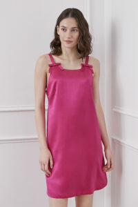 A woman wearing a red Glitter short dress with bow details at the shoulders.