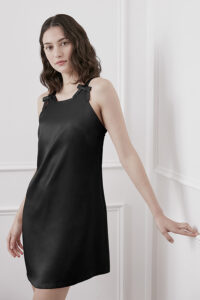A woman modeling a black Glitter short dress, showcasing the elegant shoulder straps.