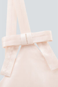 Close-up of the short pink Glitter dress showing the bow design and rhinestone accents on the shoulder.