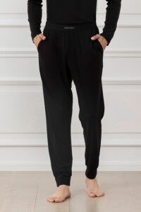 Man wearing black athletic silk track pants with comfortable waistband.