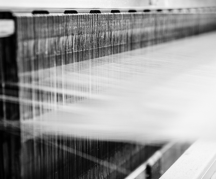 Close-up of silk threads on the loom, showcasing the meticulous weaving process at MANITO.
