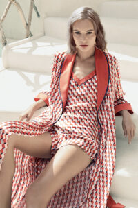 Infinite Women's Long Silky Robe featuring a geometric pattern and contrast collar, model sitting on a white couch.