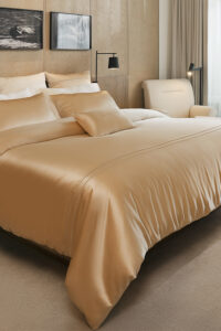 MANITO Infinity Mulberry Silk Duvet Cover in a king-size bed setup, featuring a smooth, golden silk sheen.