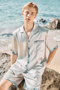 MANITO Inkmark Men's Short Pajama Set with gradient blue trim, shown worn at the beach.