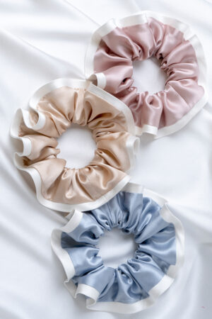 Two-tone Silk Scrunchies in pink, champagne, and blue, showing soft silk and peony-white ruffle that gently fit on hair.