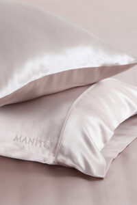 Close-up of soft pink Silk Pillowcase Set with embroidered logo of MANITO.