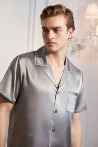 Elegant man in a luxurious flint gray silk short pajama set with contrasting piping detail.
