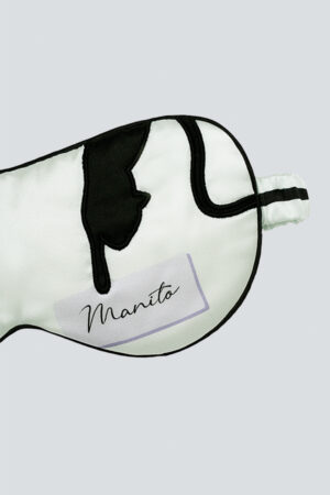 Detail shot of MANITO cat eye mask in mint green with cat head embroidery and signature branding.