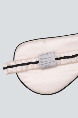 Back view of MANITO cat eye mask in pink showing soft elastic band and care label.