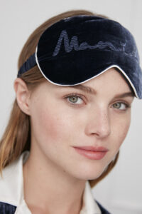 Close-up of a woman wearing Ladylike Silk Velvet Blue Eye Mask with "MANITO" embroidered detail.