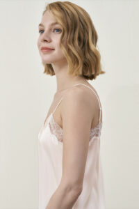 Side view of MANITO Latica Lace Silk Camisole Top in ivory worn by model.