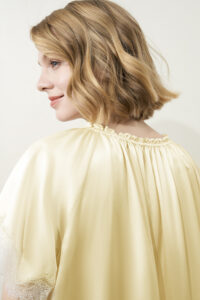 Back view of female model in the yellow MANITO Luella Lace Silk Short Sleeve Dress.
