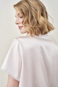 Back detail of MANITO Lunavie Women's Silk Short Sleeve Pajama Set in soft pink, highlighting smooth silk texture and lace edge.