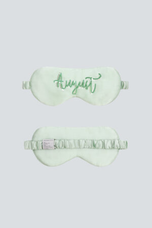 Mint green Lune Silk Eye Mask embroidered with “August” in green sequins.