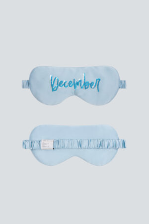 Light blue Lune Silk Eye Mask with “December” sequin embroidery and soft silk band.