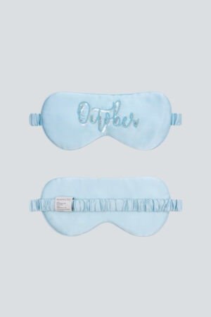 Light blue October Lune Silk Eye Mask with sequin month embroidery and elastic band.