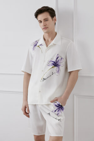 Model in a white Lrisette Unisex Floral Silk Shirt featuring delicate purple blooms, showcasing modern elegance.