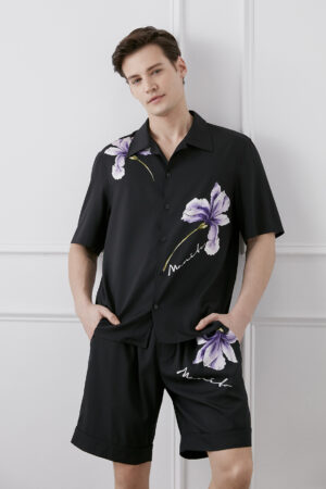 Model wearing a black Lrisette Unisex Floral Silk Shirt with striking purple flower prints.