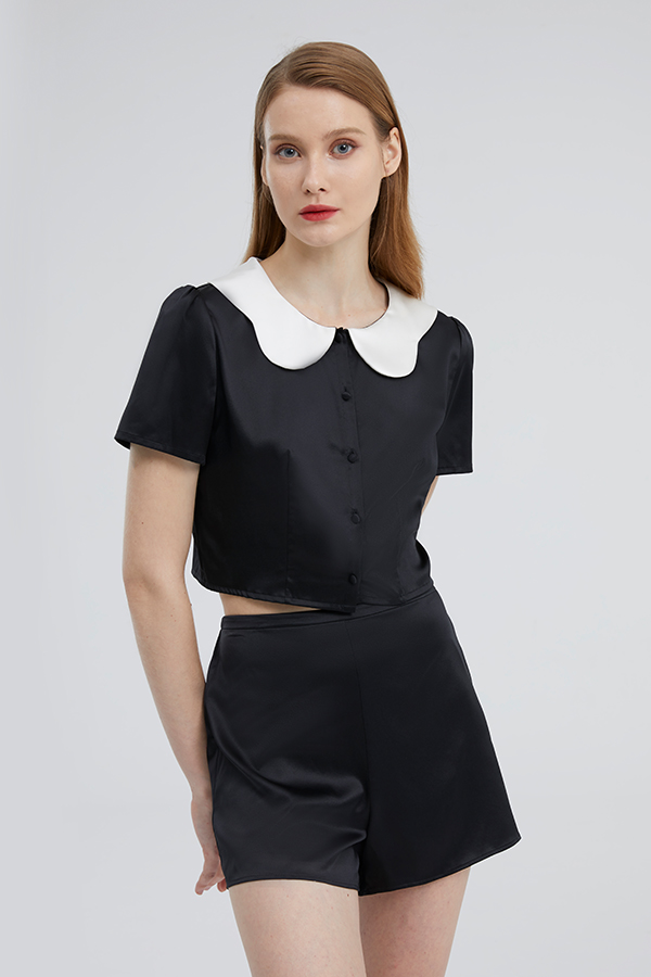 Chic Doll short loungewear set with a doll collar in black silk on a poised woman.