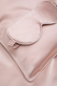 Close-up of the HA Silk Pillowcase & Eye Mask Gift Box in blush pink, highlighting the soft silk eye mask and pillowcase.