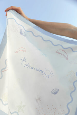 Close-up of MANITO Ocean Wave Silk Scarf with dolphin, seashell, and jellyfish prints on smooth mulberry silk.