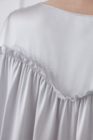 Close-up of back embroidery detail on Sophia silk mini dress, featuring "MANITO Silk Moment" embroidery.