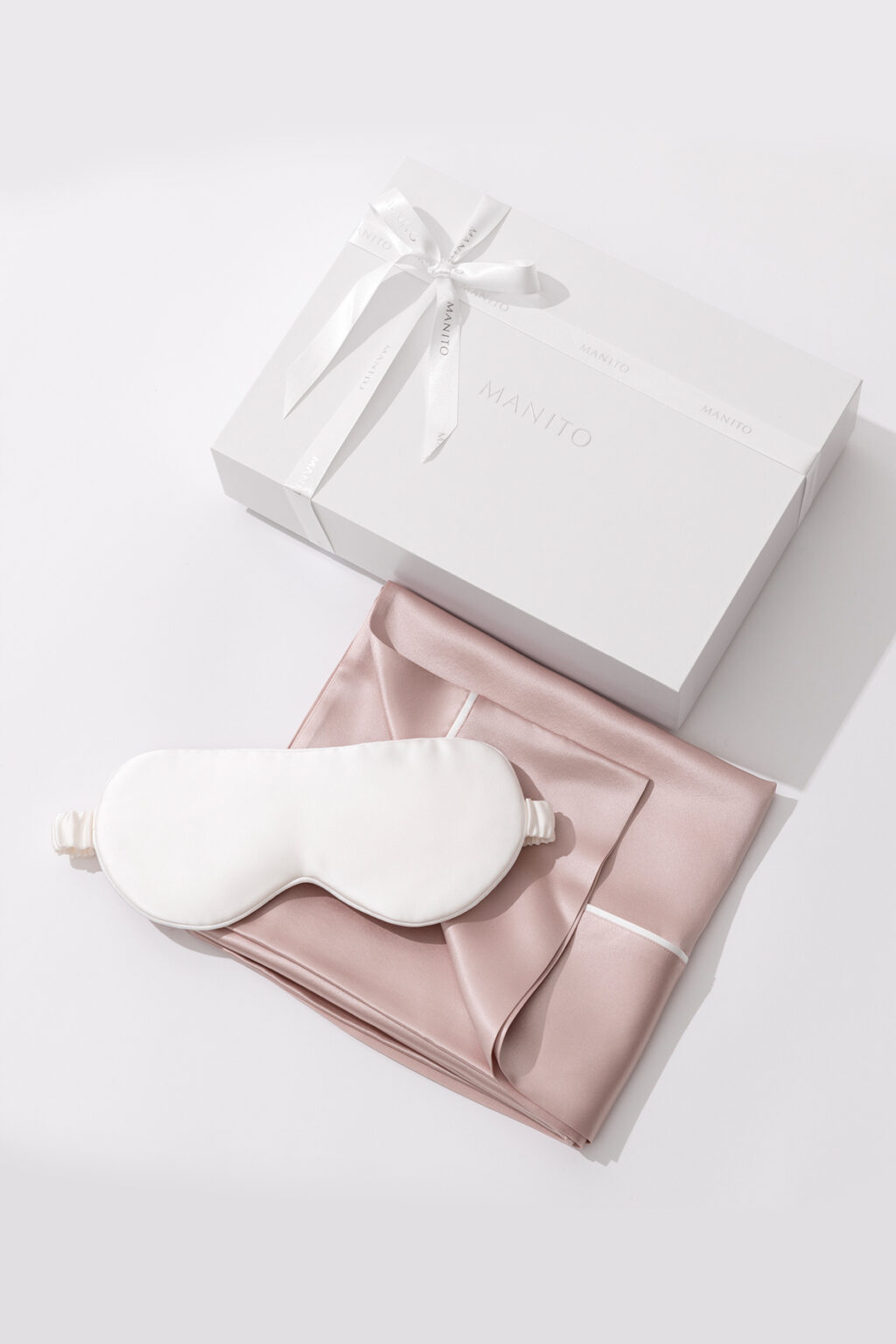 Sweet Dreams Silk Pillowcase & Eye Mask Set with pink silk pillowcase, white silk eye mask, and MANITO gift box.