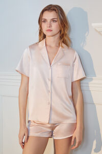 Woman in a soft pink Treasure Short Pajama Set with delicate trim details, offering a blend of comfort and style