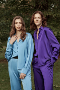 Elegant women in Vibrant Silk Set with a soft blue shirt and vibrant purple attire reflecting high-quality silk fabric.