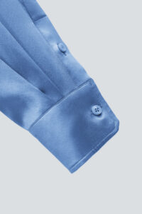 Detailed view of the Vibrant Silk Shirt blue cuff with refined button design.