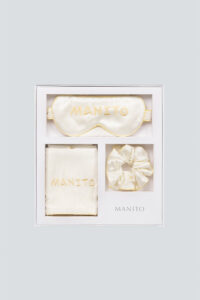 Luxury creamy white MANITO macaron silk eye mask gift box set displayed with eye mask, scrunchie, and pillowcase.