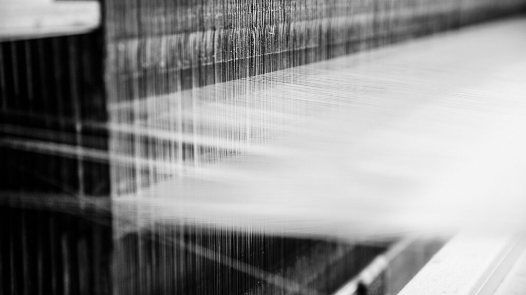 The sustainable silk threads on a loom in an eco-friendly textile manufacturing process, highlighting the sustainability of silk production.