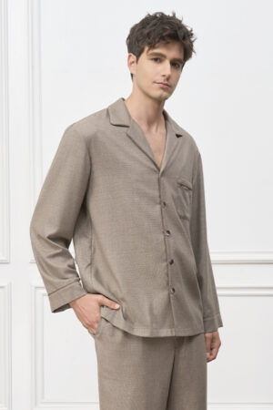 Man wears Maple Men's Pajama Set in earthy brown check, standing relaxed with one hand in pocket.