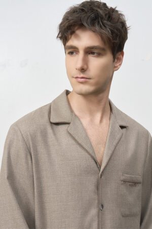Close-up of man in Maple Men's Pajama Set top, showing notched collar, chest pocket, and subtle brown check texture.