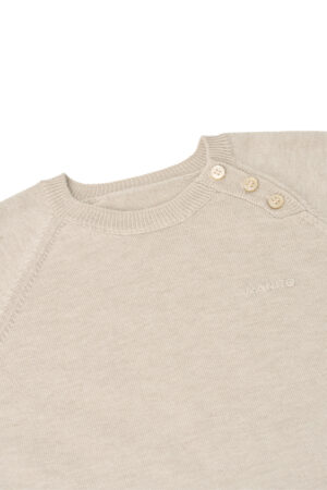 Close-up of Mellow Baby's knit onesie shoulder, highlighting the ribbed neckline and small side buttons.
