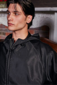 Male model wearing Monogram Cotton Silk Hoodie in black with subtle shine and relaxed fit.