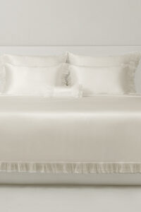 Full view of Moonlight bedding in soft silk with lace trim, creating an elegant bedroom atmosphere for quiet luxury.