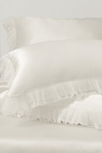 Stacked pillowcases from Moonlight silk collection showcase smooth silk texture and refined lace ruffles for a romantic look.