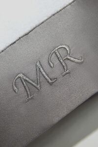 Mr. & Mrs. Bath Towel close-up of MR embroidery on gray silk trim, highlighting smooth texture and premium stitching.