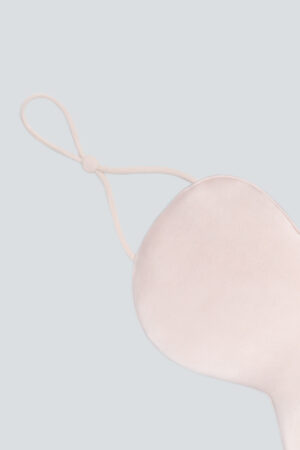 Close-up of pink Cozy Silk Eye Mask elastic ear tab made with premium Soft Light® silk.