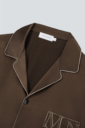 Close-up of MANITO Neat Men's Lounge Set in dark brown with ivory piping details.