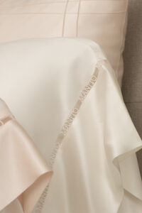 An up-close shot of the minimalistic MANITO logo hollow lace, intricately woven with yarn on MANITO New Aqua Bedding Sets.