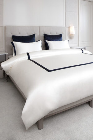 MANITO French bedding set with white silk duvet cover and navy trim, creating an elegant and refined bedroom aesthetic.