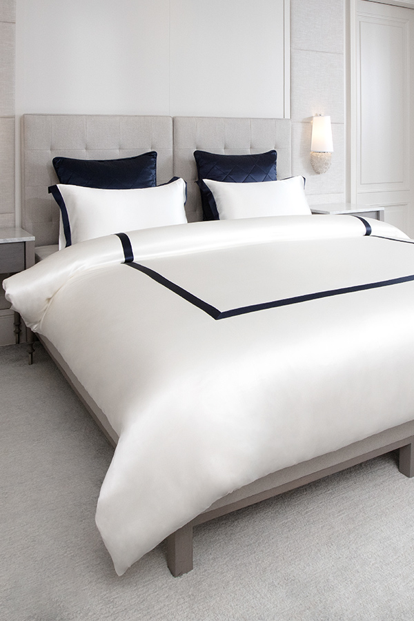 MANITO French bedding set with white silk duvet cover and navy trim, creating an elegant and refined bedroom aesthetic.