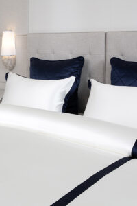 Elegant MANITO white silk bedding set with navy accents, featuring smooth, high-quality fabric.