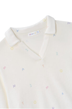 Close-up of New Signature Children's Knit Pajama top, showing the soft collar and playful letter patterns on white knit.