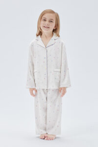Full-body view of child in New Signature Kid's Pajama Set featuring two front pockets and lively design.