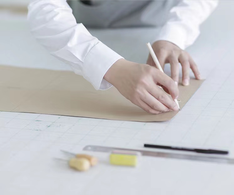 MANITO's design expert meticulously drafting custom silk designs with precision for bespoke personalization