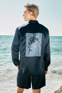 Back view of model in MANITO Ocean Blue Dolphin Men's Pajama Set showing dolphin graphic panel.